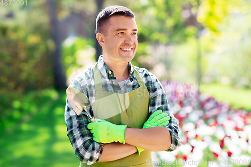 Image of happy man in apron with scoop at summer garden