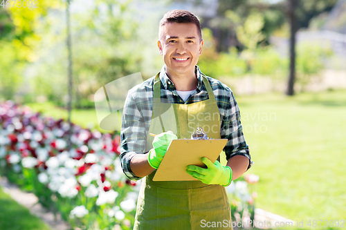 Image of happy man with clipboard at summer garden