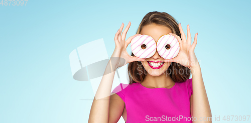 Image of happy woman or teen girl looking through donuts
