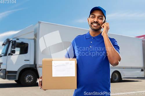 Image of indian delivery man with smartphone and parcel box