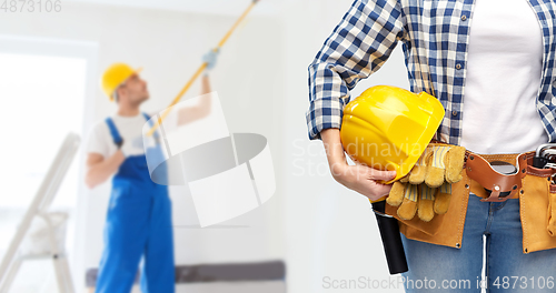 Image of woman or builder with helmet and working tools