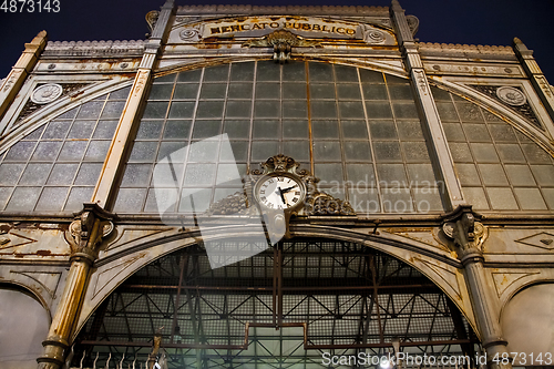 Image of Old clock hanging on ancient market wall.