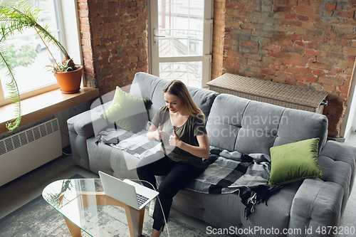 Image of Young woman, businesswoman working or studying at home, looking on computer screen, monitor. Attented, concentrated. Copyspace. Top view.