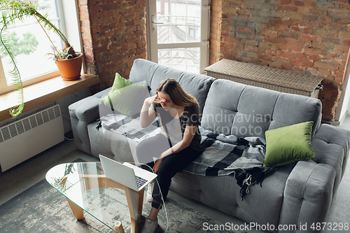 Image of Young woman, businesswoman working or studying at home, looking on computer screen, monitor. Attented, concentrated. Copyspace. Top view.