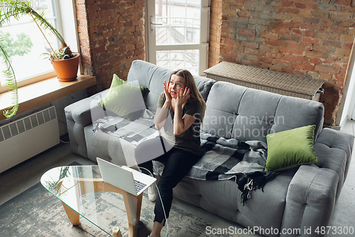 Image of Young woman, businesswoman working or studying at home, looking on computer screen, monitor. Attented, concentrated. Copyspace. Top view.
