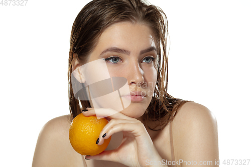 Image of Skincare. Beautiful young woman with orange over white background. Cosmetics and makeup, natural and eco treatment.