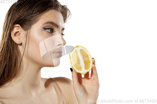 Image of Summer. Beautiful young woman with lemon slice over white background. Cosmetics and makeup, natural and eco treatment, skin care.