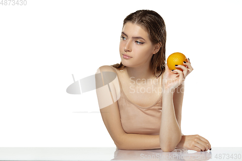 Image of Skincare. Beautiful young woman with orange over white background. Cosmetics and makeup, natural and eco treatment.