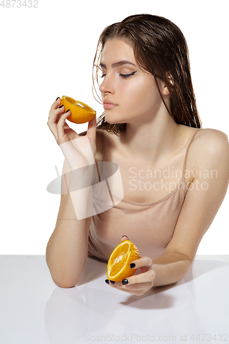 Image of Organic. Beautiful young woman with orange slices over white background. Cosmetics and makeup, natural and eco treatment, skin care.