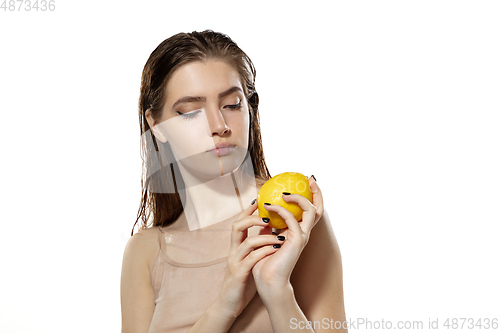 Image of Vitamins. Beautiful young woman with lemon over white background. Cosmetics and makeup, natural and eco treatment, skin care.