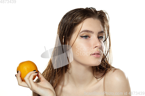 Image of Healthcare. Beautiful young woman with orange over white background. Cosmetics and makeup, natural and eco treatment, skin care.