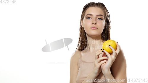 Image of Vitamins. Beautiful young woman with lemon over white background. Cosmetics and makeup, natural and eco treatment, skin care. Flyer with copyspace.