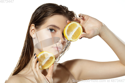 Image of Organic. Beautiful young woman with lemon slice over white background. Cosmetics and makeup, natural and eco treatment, skin care.