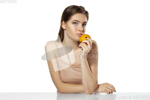 Image of Healthcare. Beautiful young woman with orange over white background. Cosmetics and makeup, natural and eco treatment, skin care.