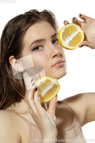 Image of Organic. Beautiful young woman with lemon slice over white background. Cosmetics and makeup, natural and eco treatment, skin care.