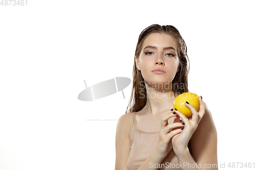 Image of Vitamins. Beautiful young woman with lemon over white background. Cosmetics and makeup, natural and eco treatment, skin care.