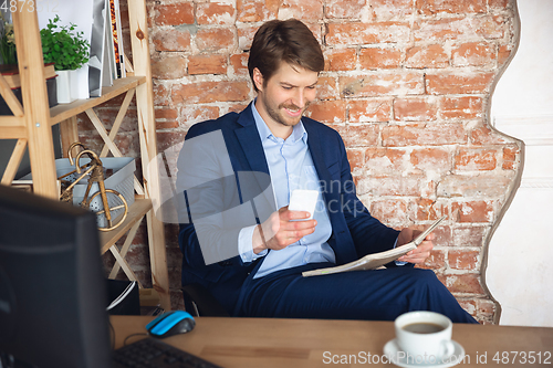 Image of Young man, manager, team led return to work in his office after quarantine, feels happy and inspired