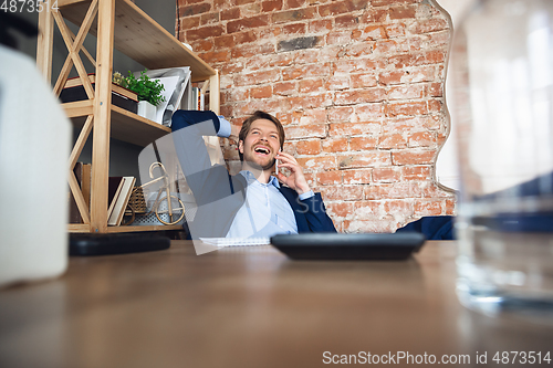 Image of Young man, manager, team led return to work in his office after quarantine, feels happy and inspired