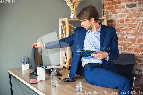 Image of Young man, manager, team led return to work in his office after quarantine, feels happy and inspired