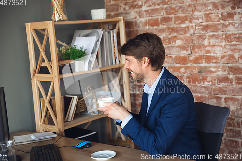 Image of Young man, manager, team led return to work in his office after quarantine, feels happy and inspired