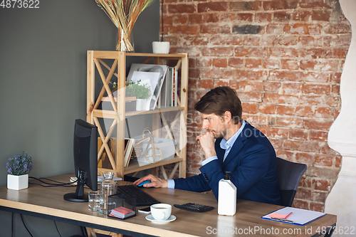 Image of Young man, manager, team led return to work in his office after quarantine, feels happy and inspired