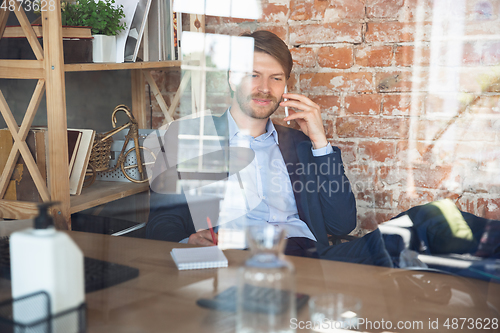 Image of Young man, manager, team led return to work in his office after quarantine, feels happy and inspired