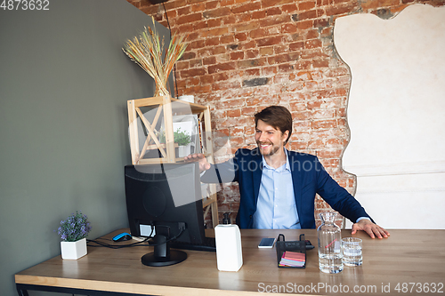 Image of Young man, manager, team led return to work in his office after quarantine, feels happy and inspired