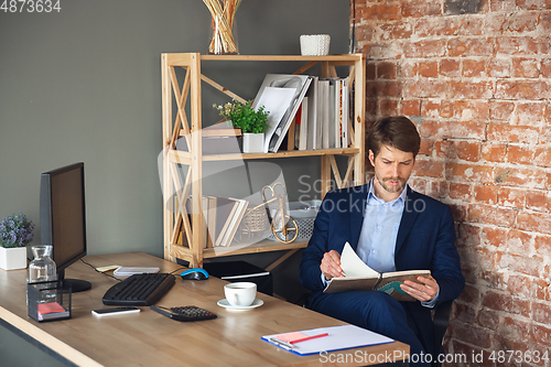 Image of Young man, manager, team led return to work in his office after quarantine, feels happy and inspired