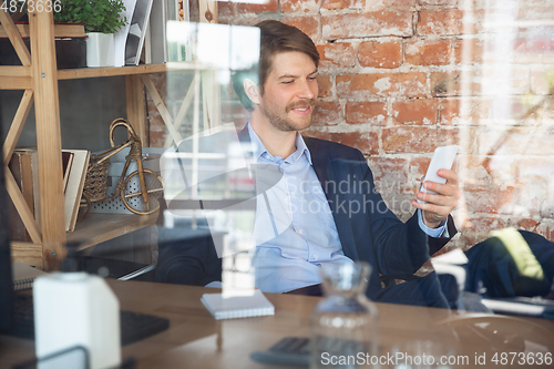 Image of Young man, manager, team led return to work in his office after quarantine, feels happy and inspired