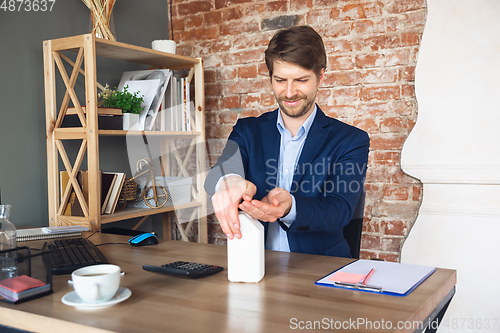 Image of Young man, manager, team led return to work in his office after quarantine, feels happy and inspired