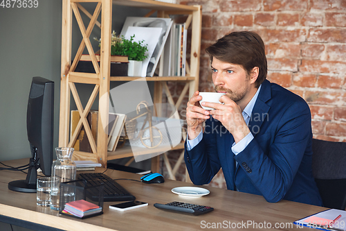 Image of Young man, manager, team led return to work in his office after quarantine, feels happy and inspired