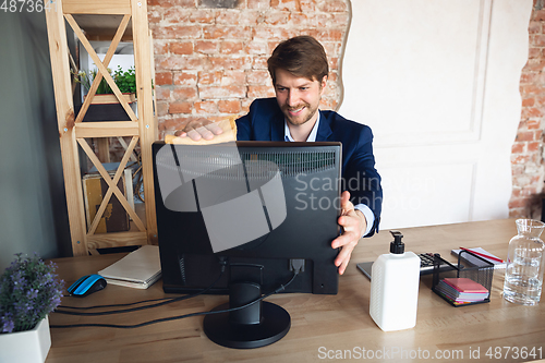 Image of Young man, manager, team led return to work in his office after quarantine, feels happy and inspired