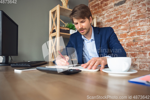 Image of Young man, manager, team led return to work in his office after quarantine, feels happy and inspired