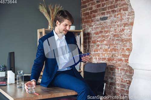 Image of Young man, manager, team led return to work in his office after quarantine, feels happy and inspired