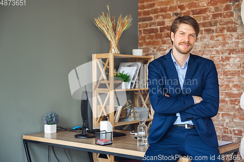 Image of Young man, manager, team led return to work in his office after quarantine, feels happy and inspired