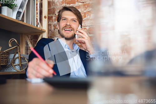 Image of Young man, manager, team led return to work in his office after quarantine, feels happy and inspired