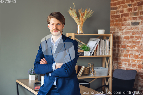 Image of Young man, manager, team led return to work in his office after quarantine, feels happy and inspired