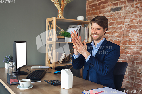 Image of Young man, manager, team led return to work in his office after quarantine, feels happy and inspired