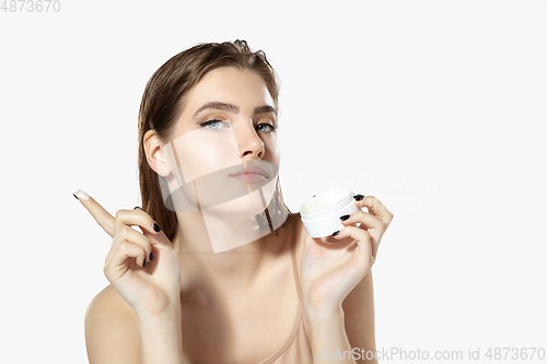 Image of Youth secrets. Close up of beautiful young woman with moisturizer over white background. Cosmetics and makeup, natural and eco treatment, skin care.