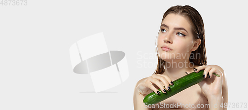 Image of Youth secrets. Close up of beautiful young woman with cucumber over white background. Cosmetics and makeup, natural and eco treatment, skin care. Flyer with copyspace.