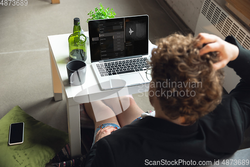 Image of Young man without pants but in jacket working on a computer, laptop. Remote office during coronavirus, fun and comfortable work in underpants