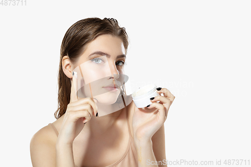 Image of Youth secrets. Close up of beautiful young woman with moisturizer over white background. Cosmetics and makeup, natural and eco treatment, skin care.