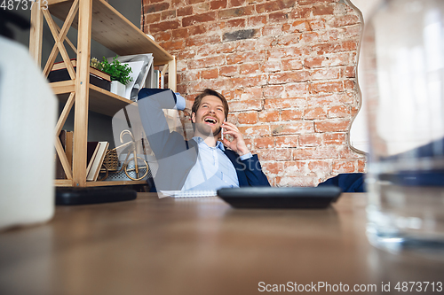 Image of Young man, manager, team led return to work in his office after quarantine, feels happy and inspired