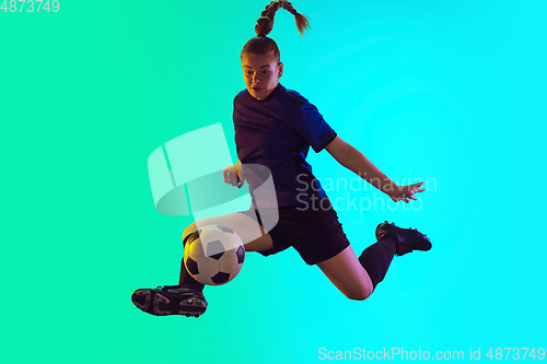 Image of Female soccer, football player kicking ball, training in action and motion with bright emotions isolated on gradient background