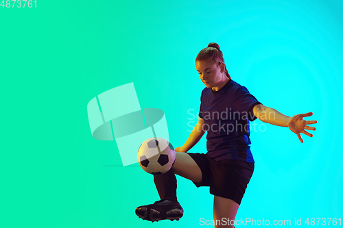 Image of Female soccer, football player kicking ball, training in action and motion with bright emotions isolated on gradient background