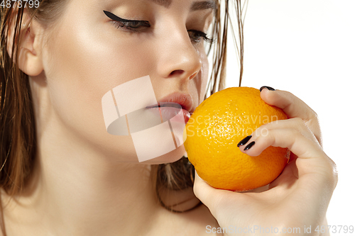 Image of Close up of beautiful young woman with juicy orange over white background. Cosmetics and makeup, natural and eco treatment, skin care.