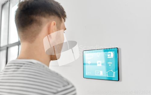 Image of man looking at tablet computer at smart home