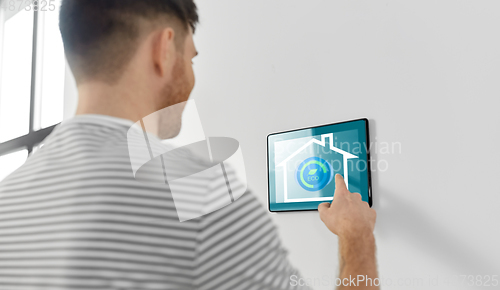 Image of man looking at tablet computer at smart home