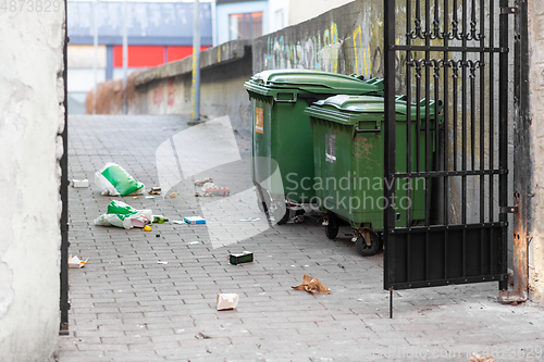 Image of dumpsters on messy city street or courtyard