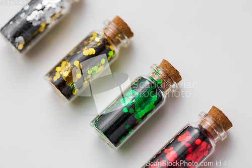 Image of set of glitters in bottles over white background